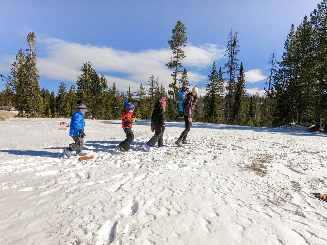 family hiking in the snow with boots on