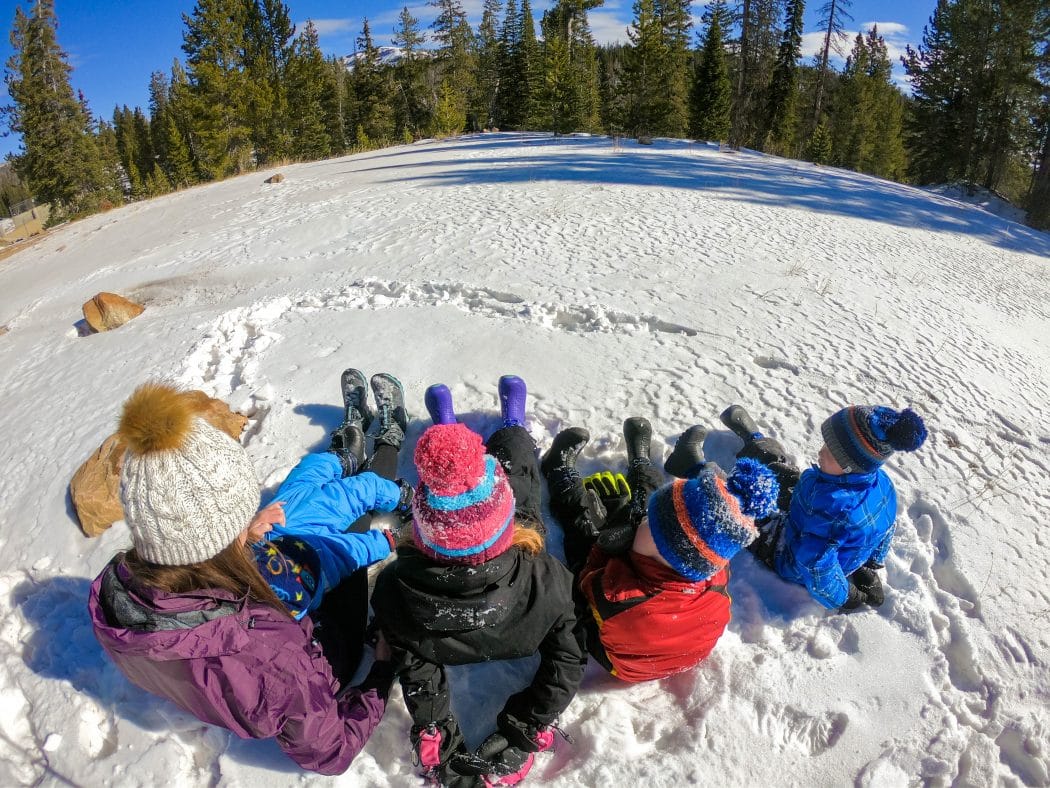 family in snow wearing snow boots