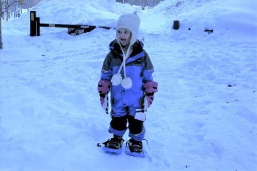 little kid in snowsuit in winter with snow