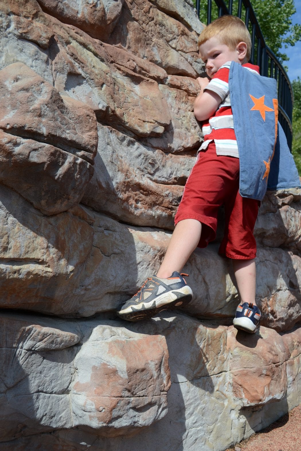 boy climbing rock wall