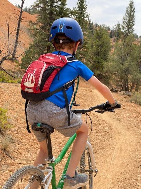 boy biking with hydration pack camelbak