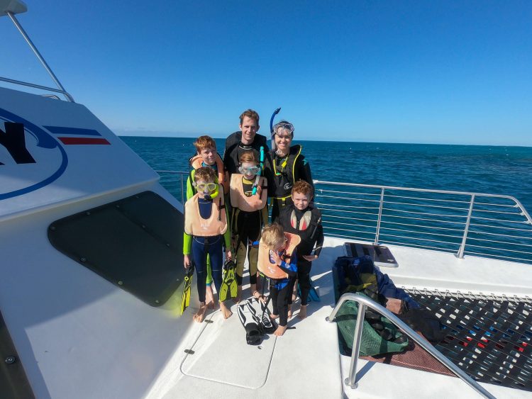 large family snorkeling in the carribean wearing life jackets while snorkeling