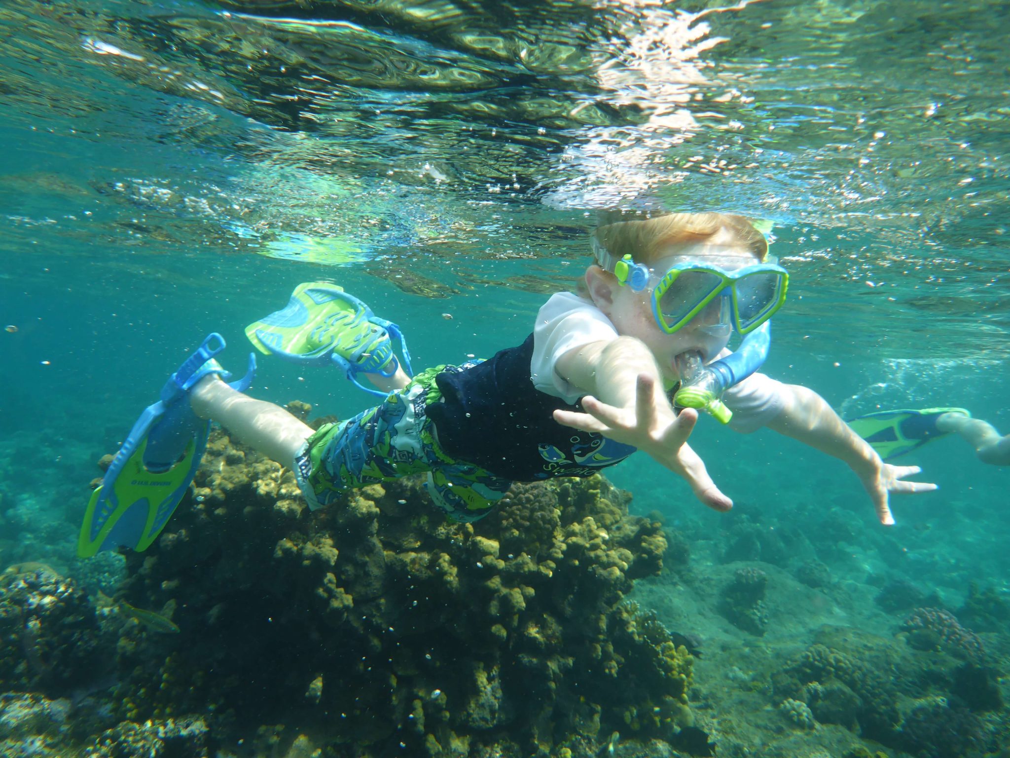 little boy snorkeling in ocean