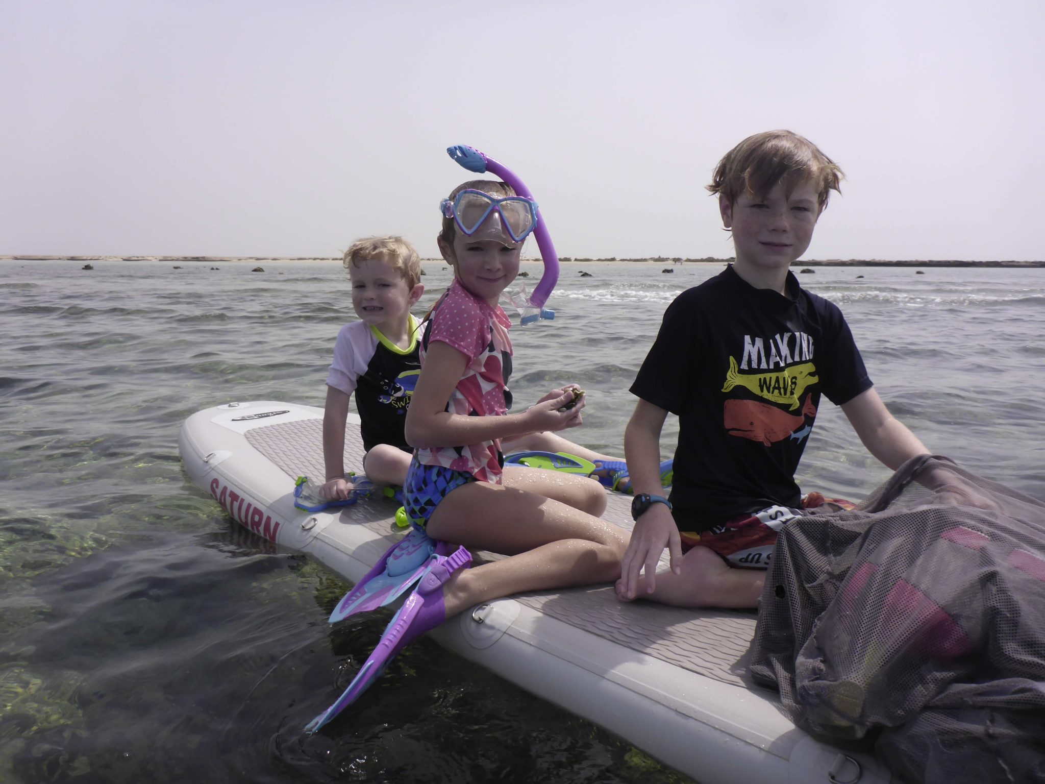 kids snorkeling on a paddleboard